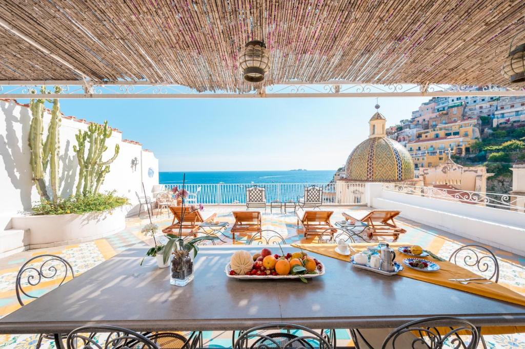 un tavolo su un balcone con vista sull'oceano di Villa Petite Syrene by Elite Villas a Positano