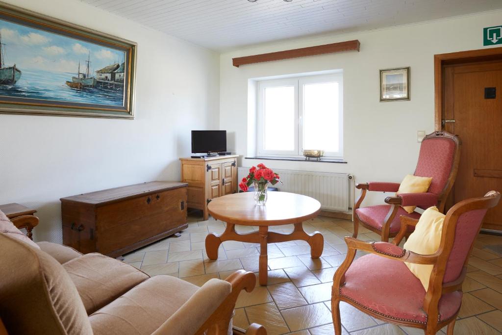 uma sala de estar com um sofá e uma mesa em Le renard qui fume em Onhaye