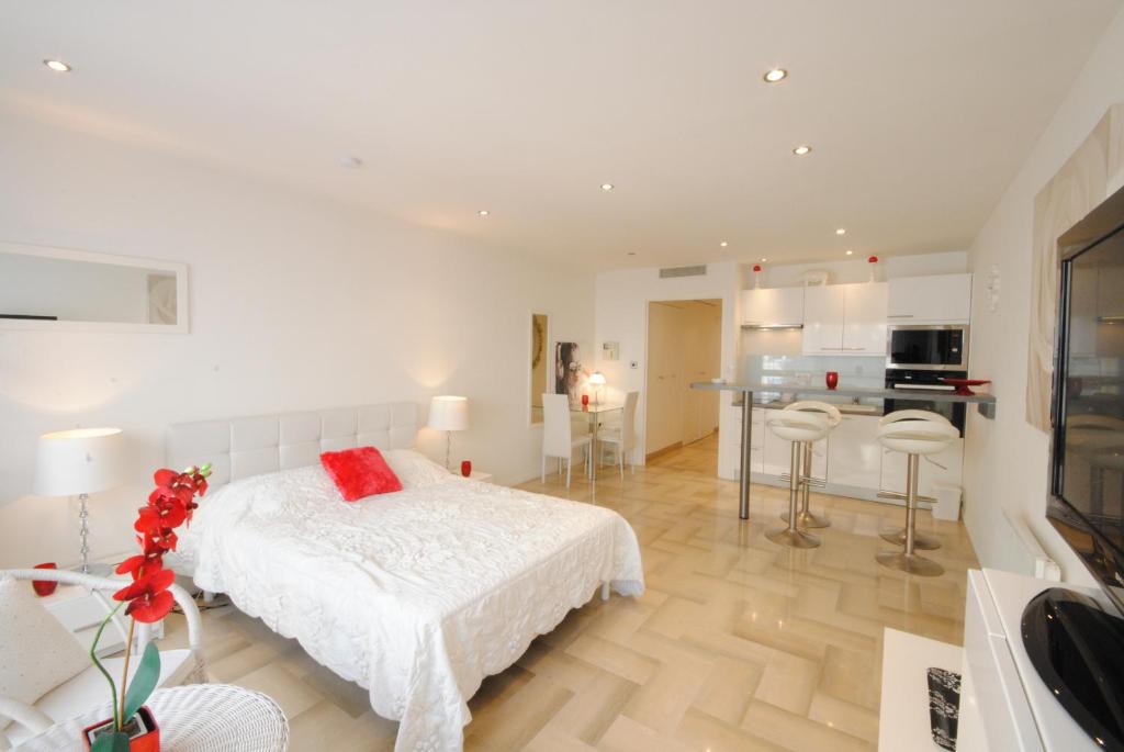 une chambre blanche avec un lit et une cuisine dans l'établissement Gray d Albion THI235, à Cannes