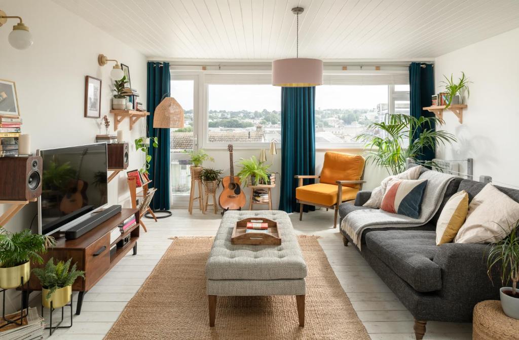 a living room with a couch and a tv at Number 4 - Stylish 1 bedroom house in Truro, Cornwall in Truro