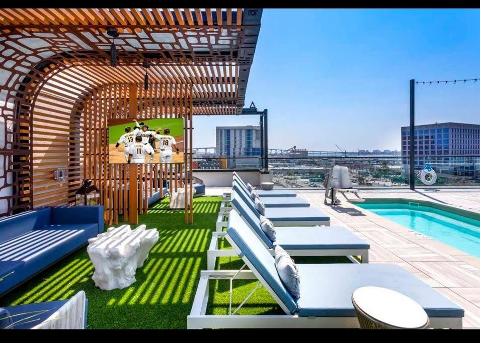 a rooftop patio with chairs and a pool on a building at Lux Apt with Rooftop pool by Petco Park and Convention center 41 in San Diego