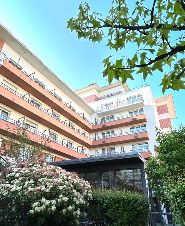 a large building with balconies and flowers in front of it at Residhome Paris-Evry in Courcouronnes