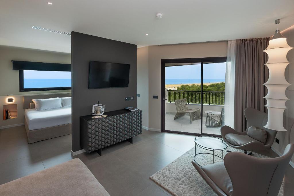 a living room with a bed and a room with a balcony at Savoy Beach Hotel & Thermal Spa in Bibione