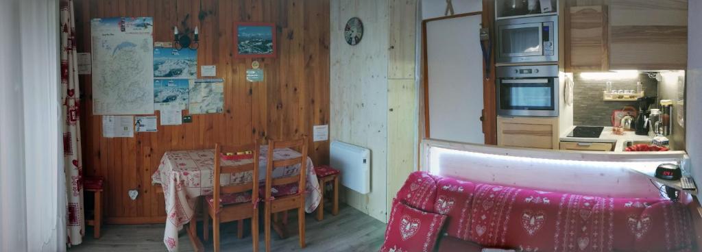 eine Küche mit einem Tisch und Stühlen im Zimmer in der Unterkunft Studio Praz de lys - Les pralyssimes in Taninges
