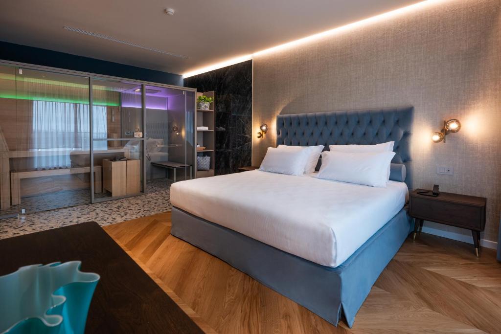 a bedroom with a large bed and a bathroom at Savoy Beach Hotel & Thermal Spa in Bibione
