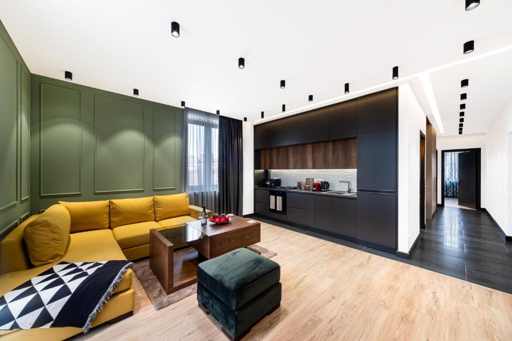 a living room with a yellow couch and a kitchen at hotelise I Palermo Apartment in Yerevan