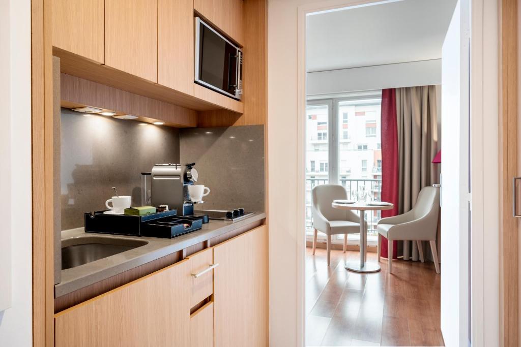 a kitchen with a sink and a table at Residhome Paris-Evry in Courcouronnes