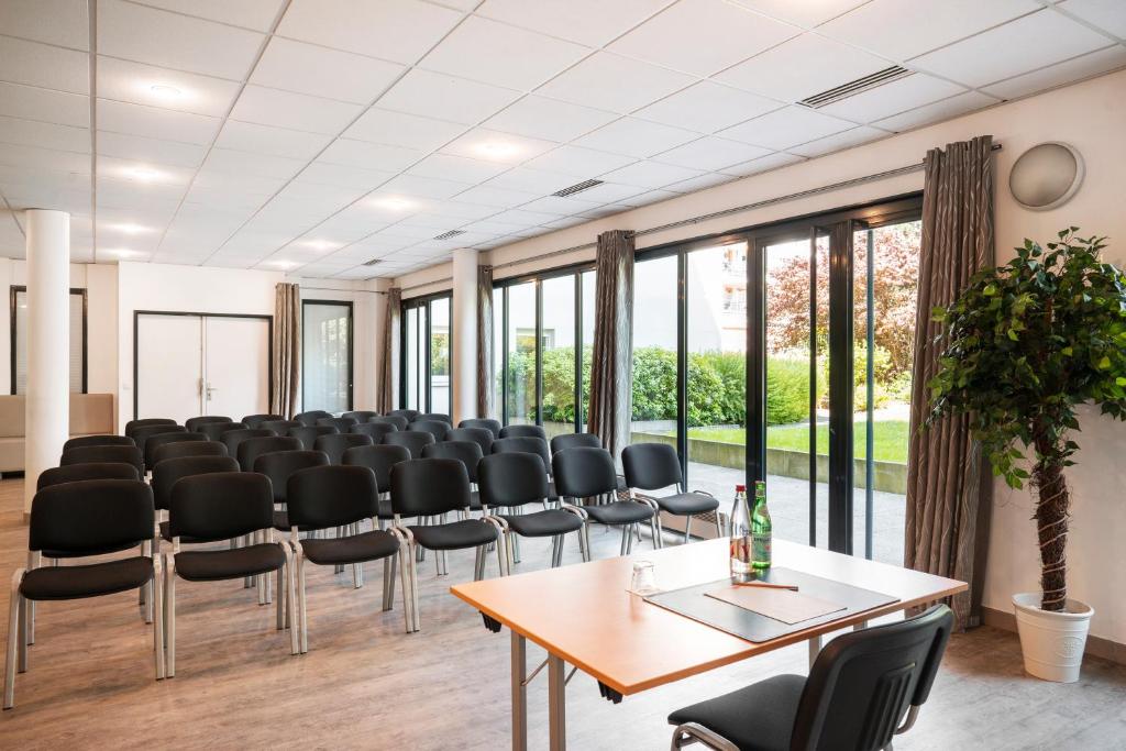 a conference room with black chairs and a table at Residhome Paris-Evry in Courcouronnes