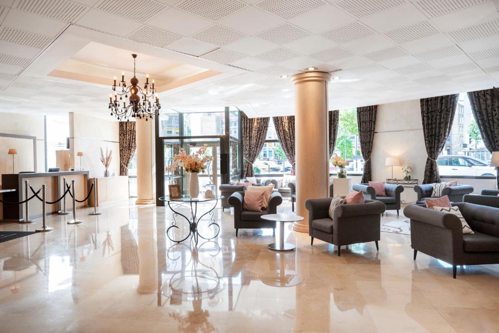 a lobby with couches and chairs and a chandelier at Residhome Paris-Evry in Courcouronnes