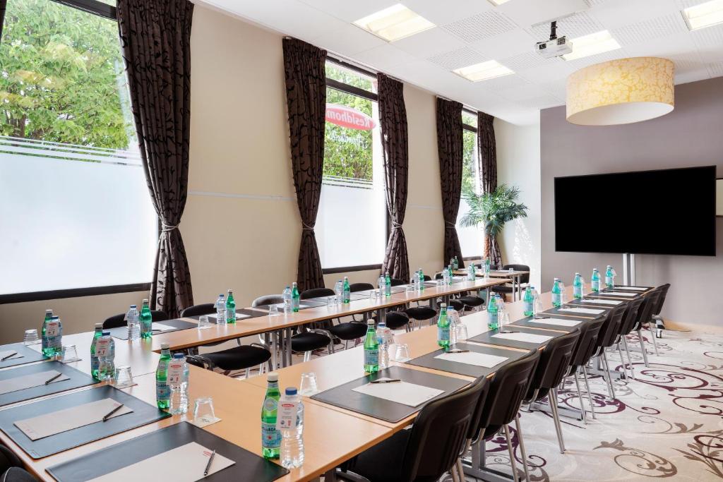 a conference room with tables and chairs with bottles on them at Residhome Paris-Evry in Courcouronnes