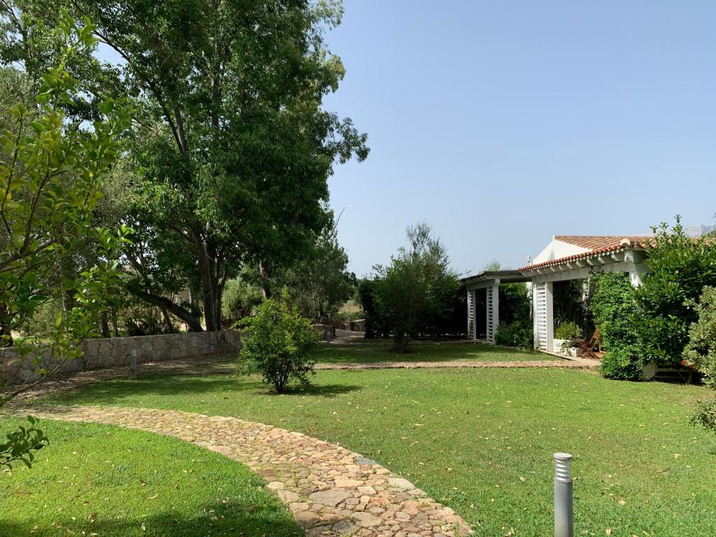 a yard with a house and a stone path at Relais BeneMari in Siniscola