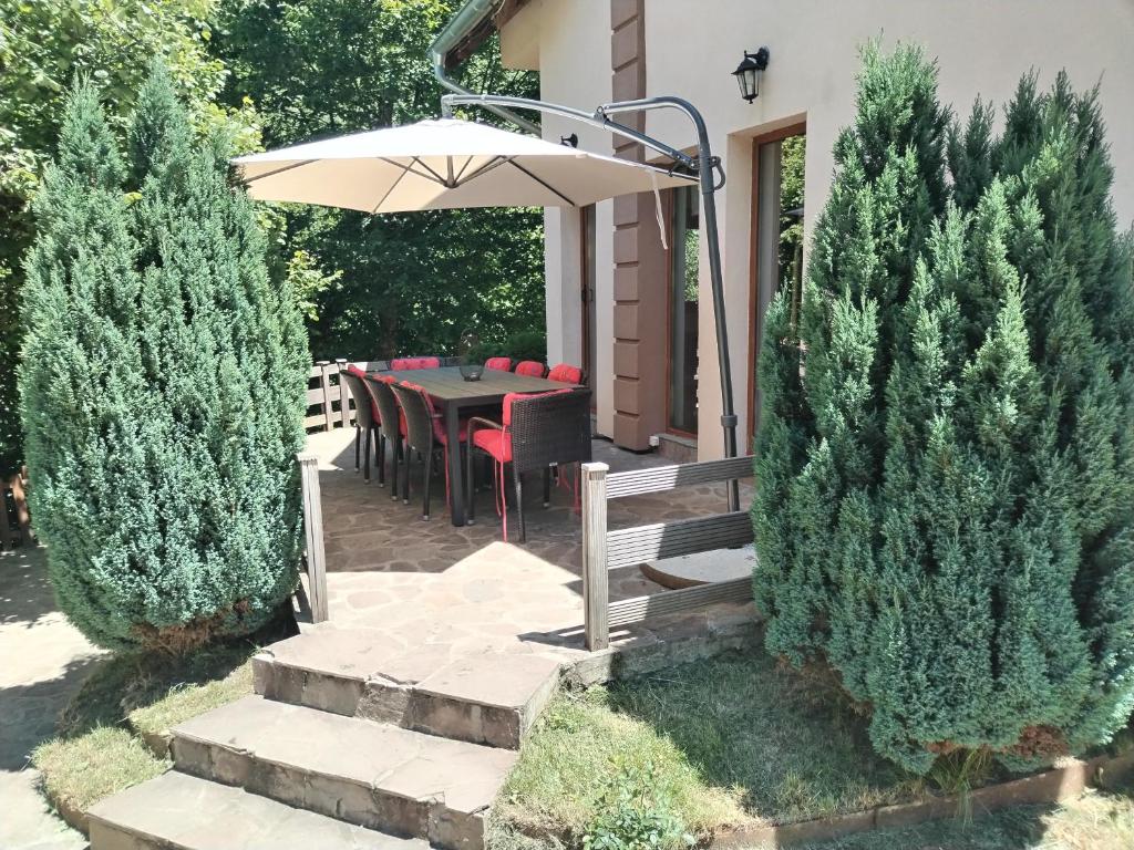 a patio with an umbrella and a table and chairs at Lodge Zeleni svet in Crni Vrh