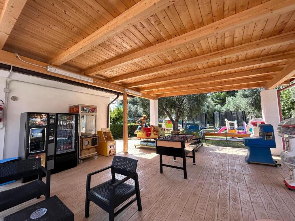 un patio con pérgola de madera, mesas y sillas en Appartamenti Vacanze Minervino, en Vieste