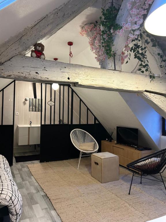 een woonkamer met een trap en een stoel bij LE LOFT DU DOUBS in Besançon