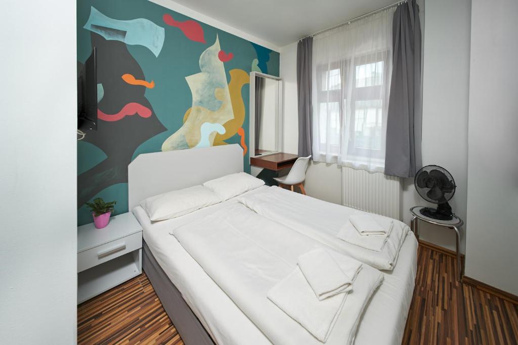 a bedroom with a white bed and a colorful wall at Akira Bed & Breakfast in Wrocław