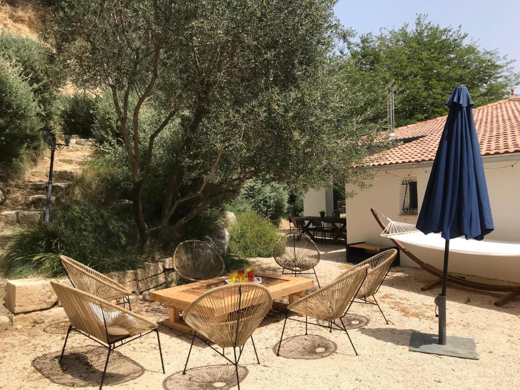 a table and chairs and an umbrella in a yard at Villa de la Tour in Bellegarde