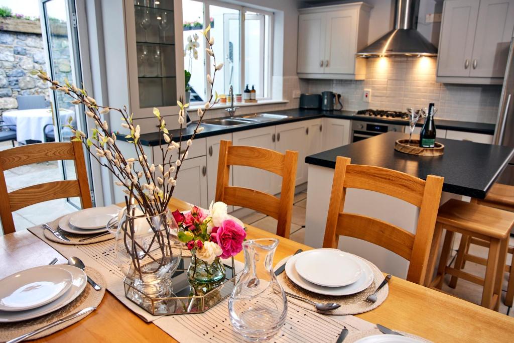a kitchen with a table with plates and flowers on it at 'Maigue View' by the River in Croom