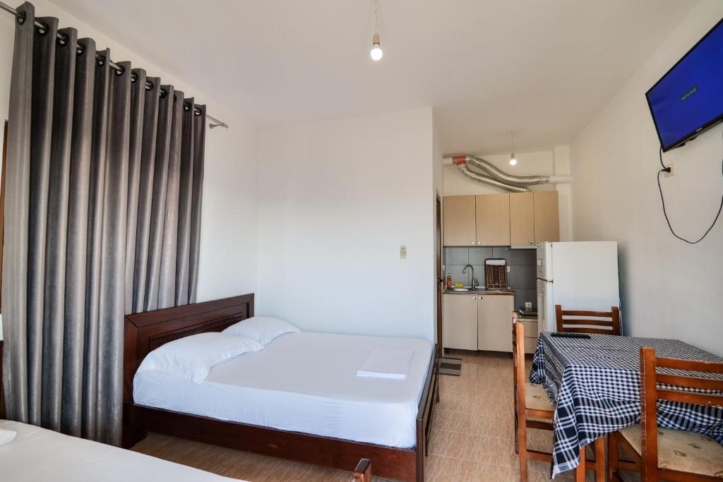 een kleine slaapkamer met een bed en een keuken bij Vila Suljo in Ksamil