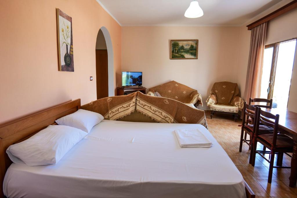 um quarto com uma cama e uma sala de estar em Vila Suljo em Ksamil