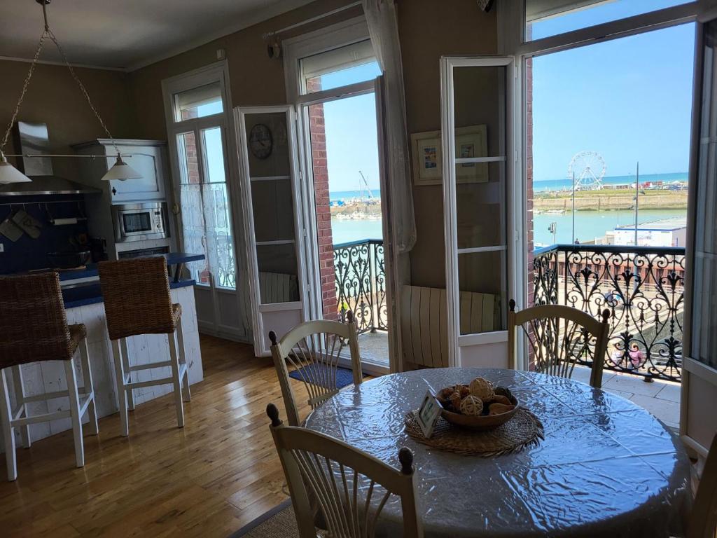 a dining room with a table with a bowl of fruit on it at Les 5 balcons in Le Tréport