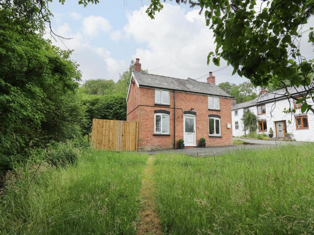 an old brick house in the middle of a field at Min Y Nant in Welshpool