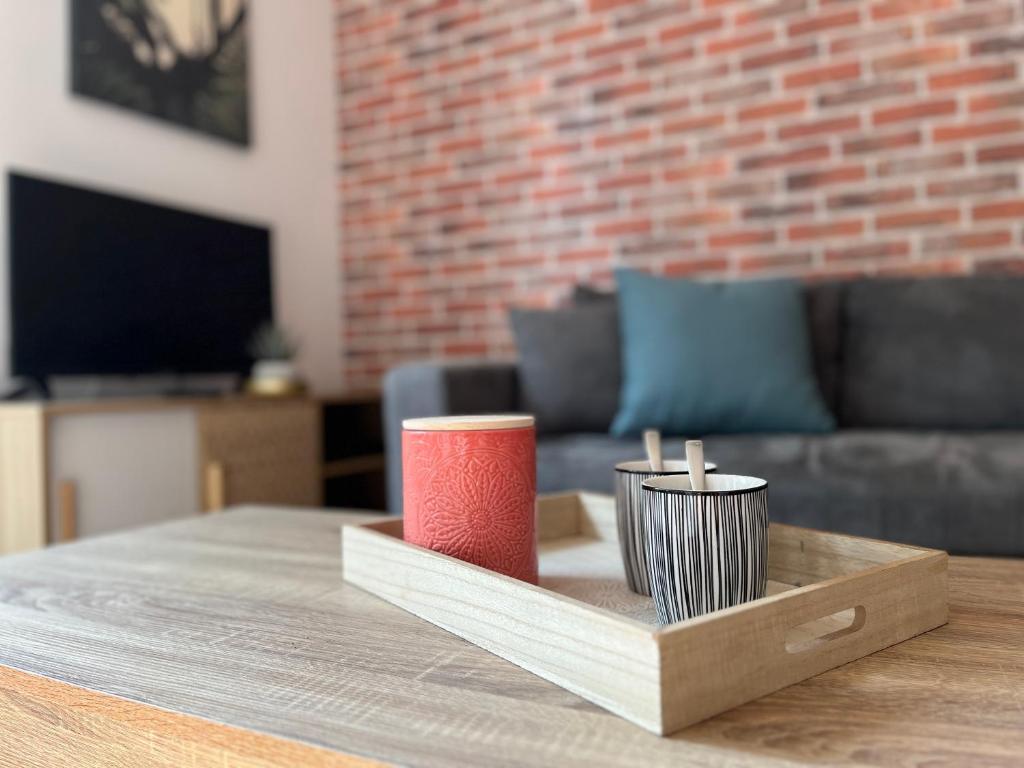 - un plateau en bois avec deux bougies sur une table dans l'établissement Le Delos - Centre ville - Parking - 2 pers, au Mans