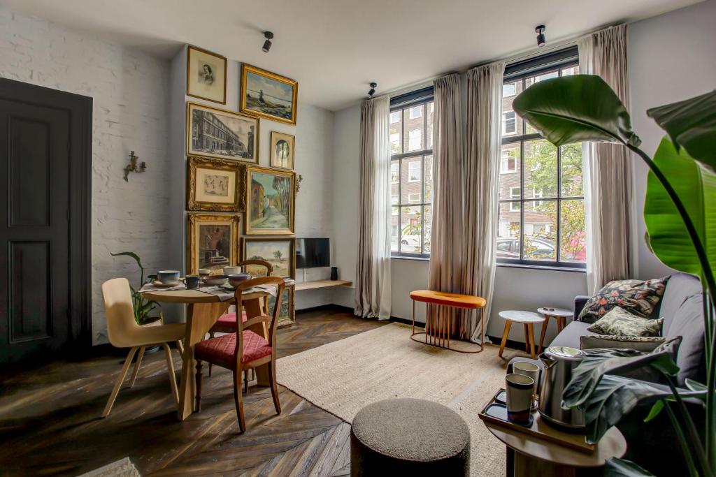 un soggiorno con tavolo e sedie di Canal House with Garden ad Amsterdam