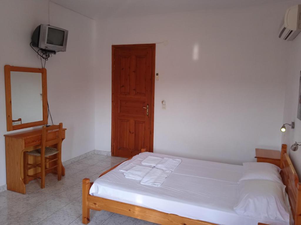 a bedroom with a bed and a dresser and a mirror at Platanakia in Skopelos Town