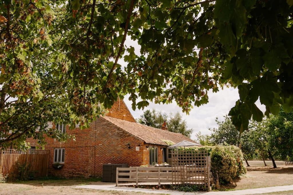a brick church with a bench in front of it at The Threshing Barn - relaxing countryside spa break in Pentney