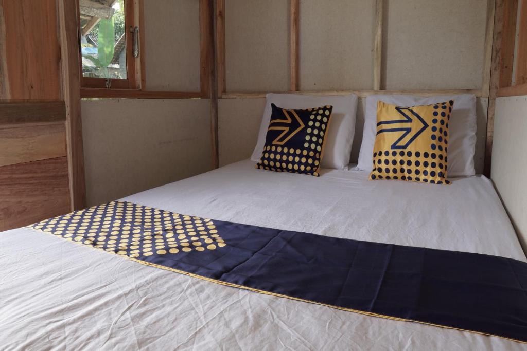 łóżko z poduszkami w pokoju w obiekcie SPOT ON 92699 Irish Irish Homestay w mieście Banyuwangi