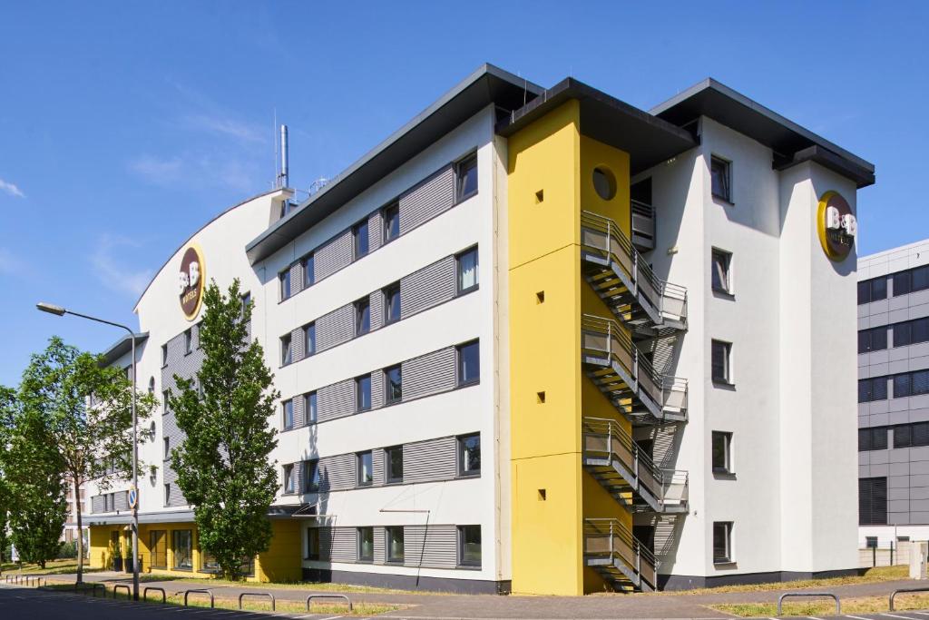 um edifício amarelo e branco em B&B HOTEL Frankfurt-Niederrad em Frankfurt am Main