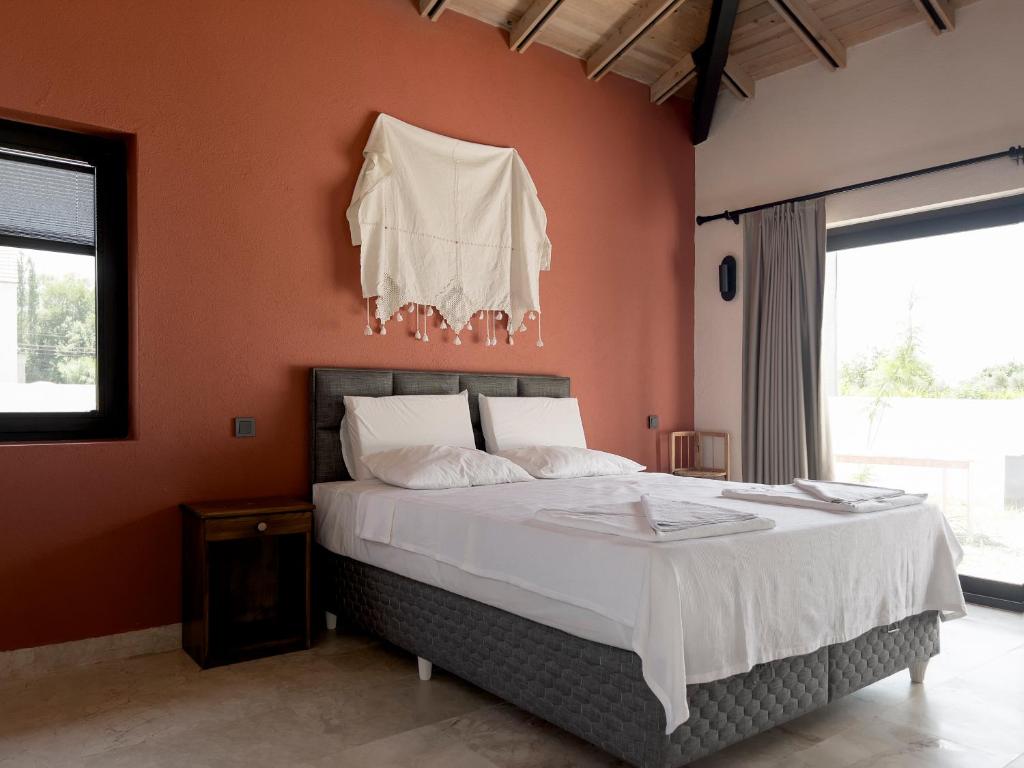 een slaapkamer met een bed met een oranje muur bij Koy Villa in Mugla