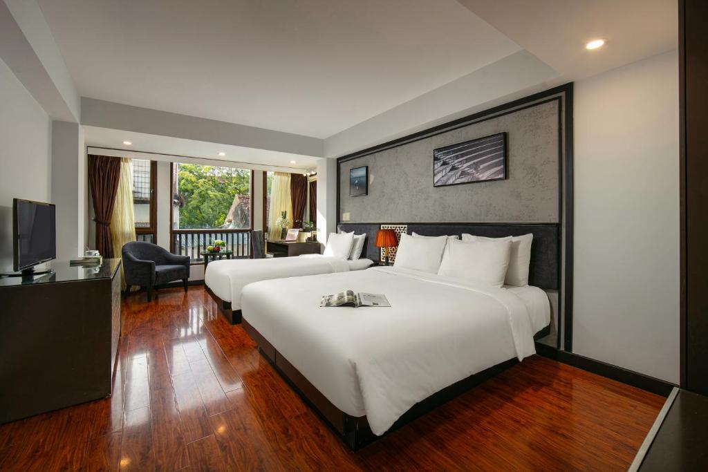 Pokój hotelowy z 2 łóżkami i biurkiem w obiekcie Hanoi La Palm Premier Hotel & Spa w mieście Hanoi