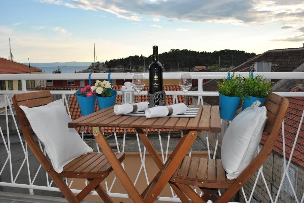 a table with a bottle of wine on a balcony at Apartment Optimist in Makarska