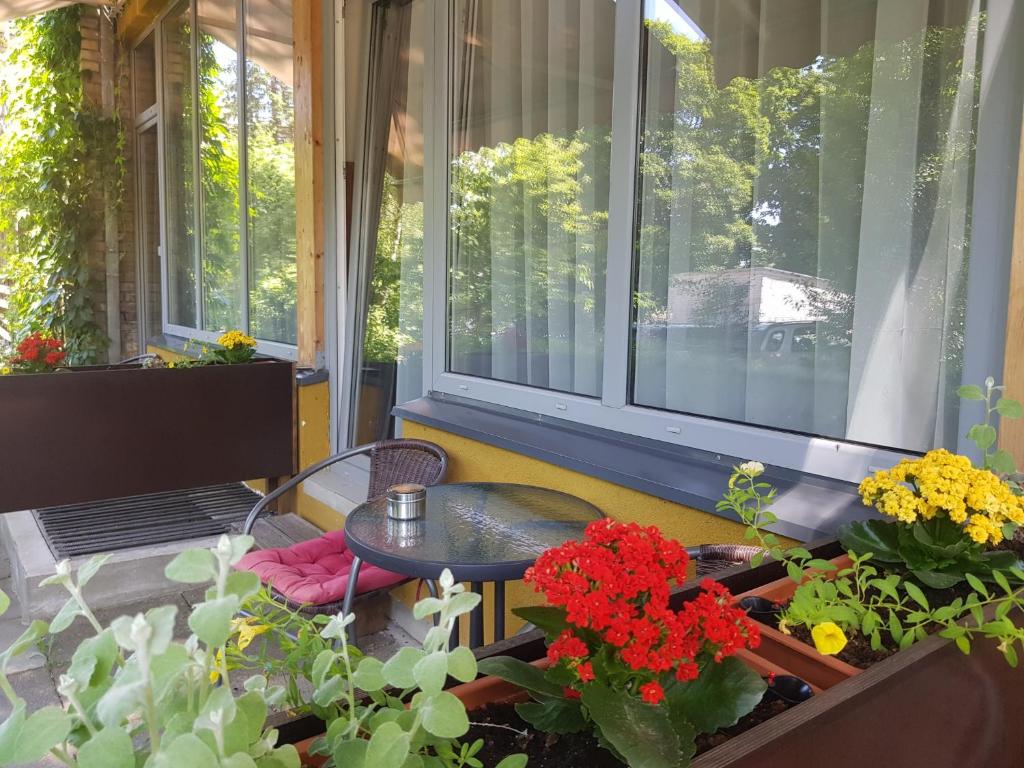 a screened in porch with flowers and a table at Nėris Inn Terraces in Vilnius