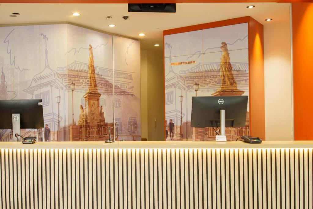 a lobby with a large wall mural of two monuments at B&amp;B Hotel Heidelberg in Heidelberg