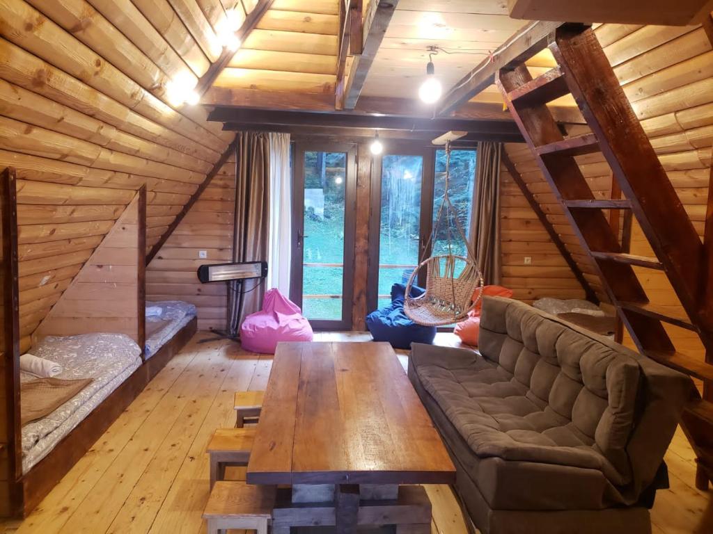 una sala de estar con sofá y mesa en una cabaña en Cottage Sochi, en Ambrolauri