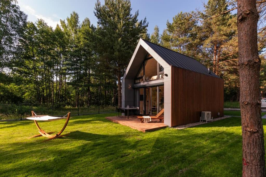 eine kleine Hütte in einem Garten mit grünem Rasen in der Unterkunft Po prostu Piękna! Domek nad jeziorem in Stare Jabłonki