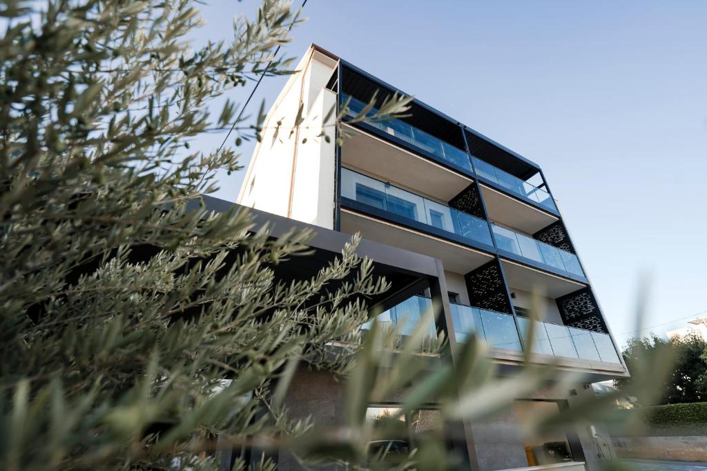 a building with glass windows and plants in the foreground at Apartments M&A in Kaštela