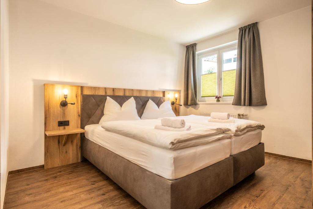 a bedroom with a large bed and a window at Alpha Apartments in Schwarzach im Pongau