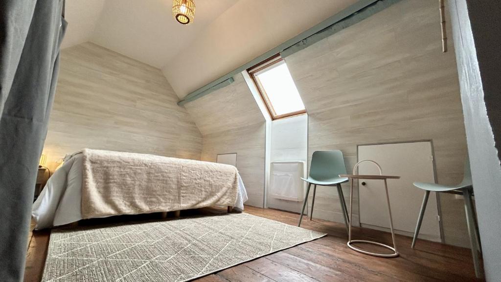 une chambre avec un lit et deux chaises dans l'établissement Jaliane, maison de pêcheur, à Saint-Valery-sur-Somme