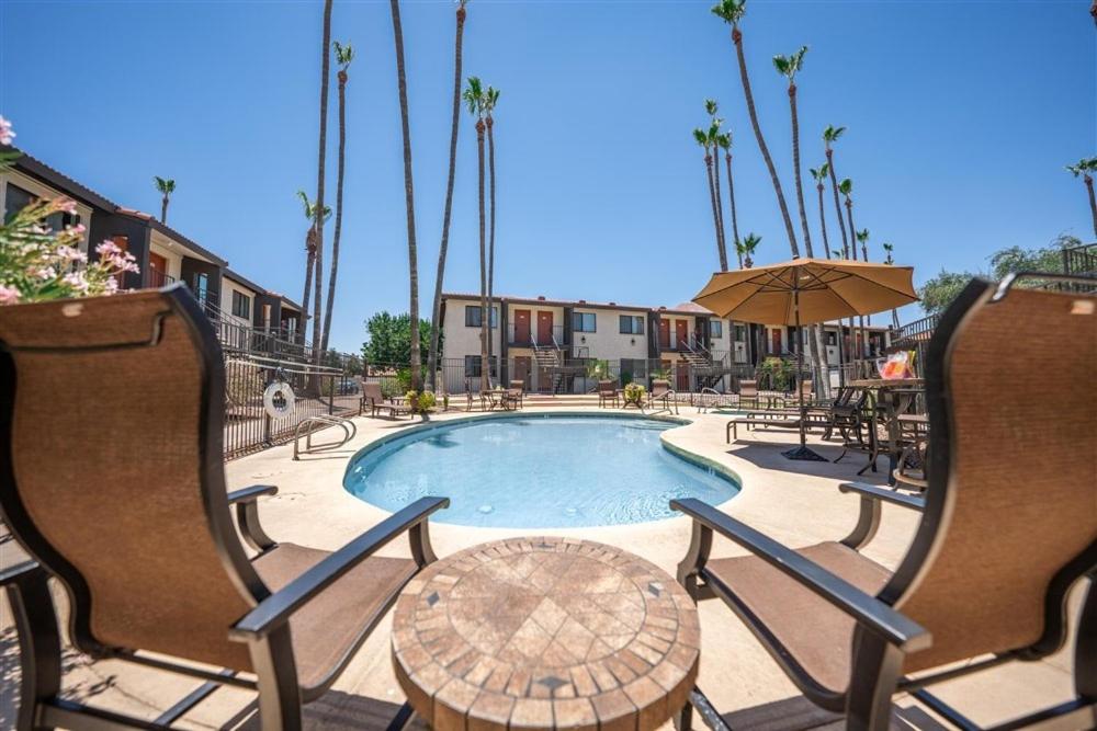 uma piscina com cadeiras, uma mesa e um guarda-sol em 216-Fully Furnished 1BR Suite-Outdoor Pool em Scottsdale