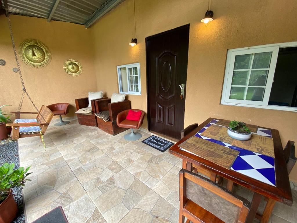 ein Wohnzimmer mit einem Tisch, Stühlen und einer Tür in der Unterkunft Hospedaje en El valle de Antón - Cabaña Rincón del Sol in Antón