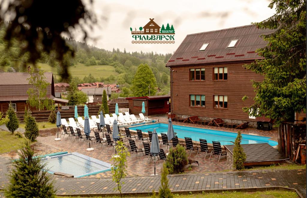 a resort with a pool and chairs and a building at Chalet Filvarok in Slavske