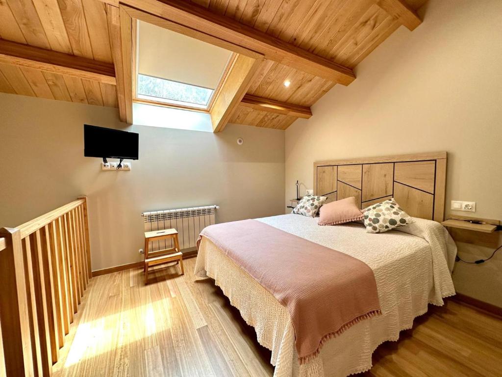 1 dormitorio con 1 cama grande y tragaluz en Apartamentos Casa Courego en Vegadeo