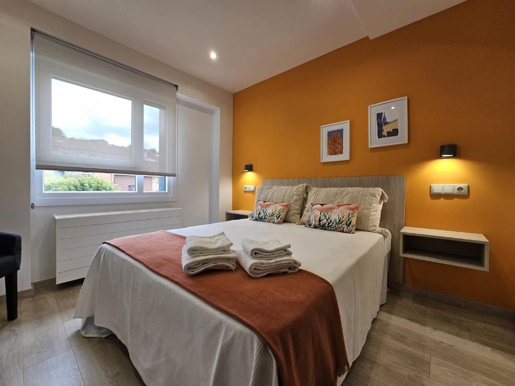 sypialnia z łóżkiem z dwoma ręcznikami w obiekcie Inicia AVIO Apartamentos w Santiago de Compostela