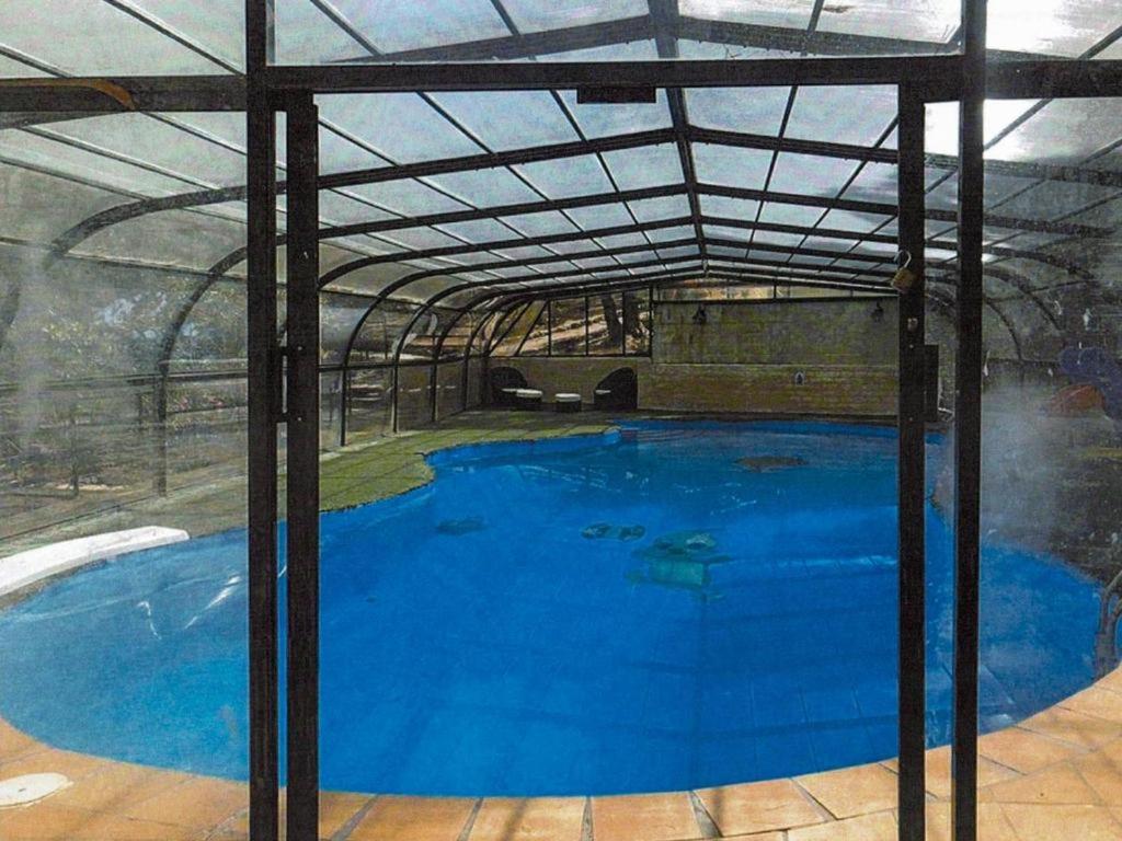 una gran piscina azul con techo de metal en Fun Bolarque, en Albalate de Zorita