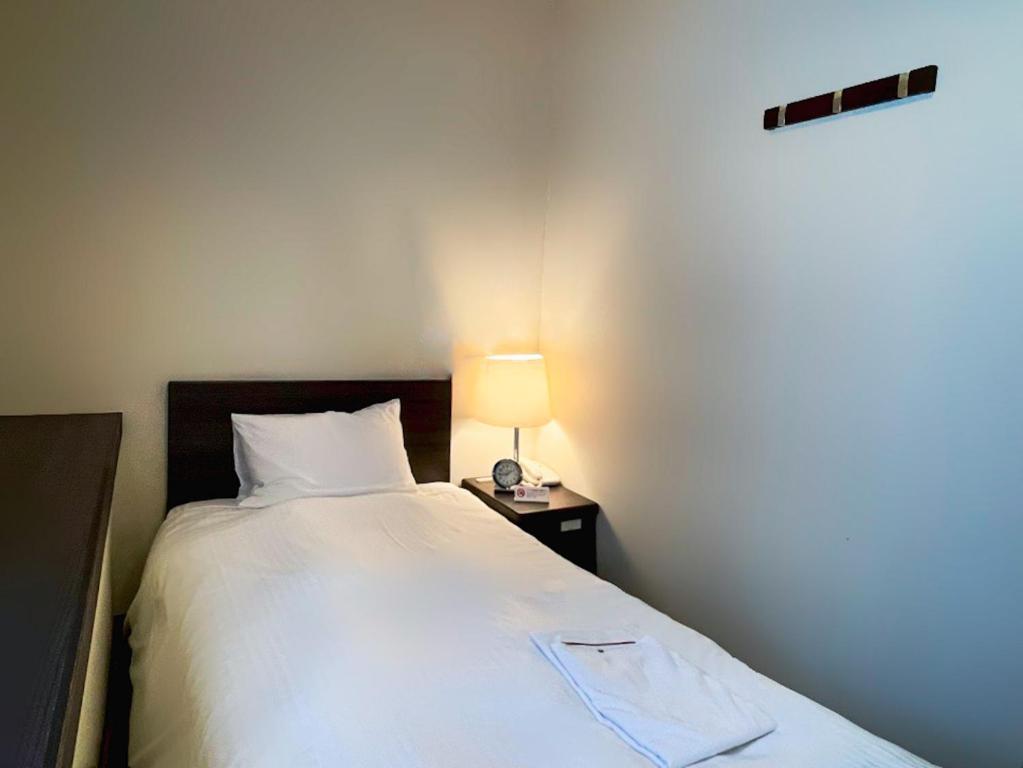 Postel nebo postele na pokoji v ubytování Shinjuku Sun Park Hotel