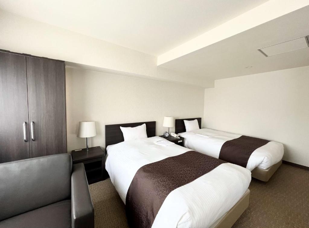 Postel nebo postele na pokoji v ubytování Shinjuku Sun Park Hotel