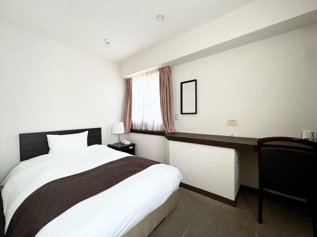 Postel nebo postele na pokoji v ubytování Shinjuku Sun Park Hotel